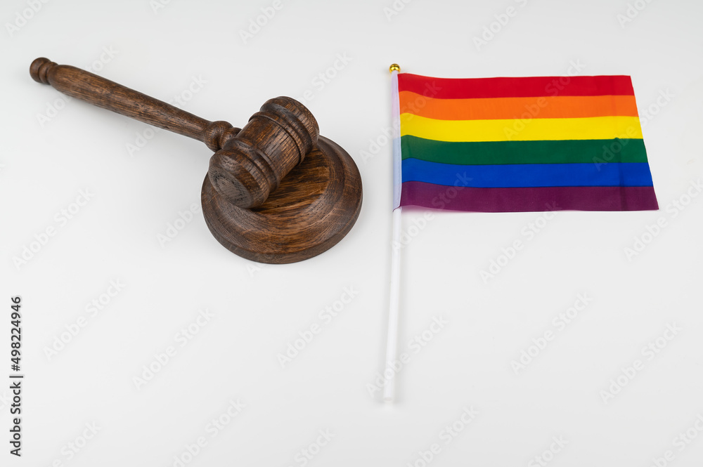 Judge gavel and hand lgbt flag on white background.