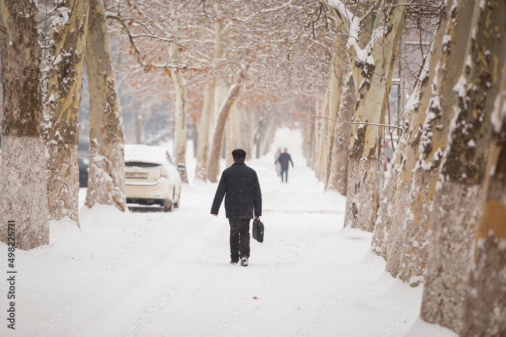 A man walks along a snowy path. Winter landscape. winter scene. Snow path.