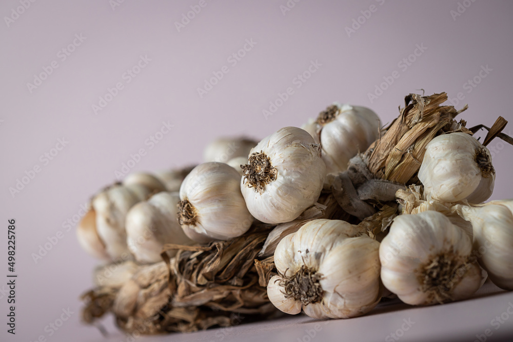 Fragrant Garlic wreath lies on light background. Agriculture and farming