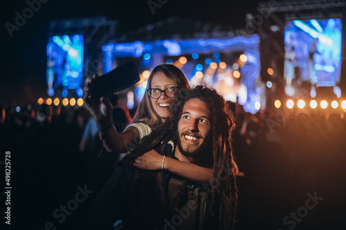 Couple taking selfie with a smartphone on a music festival