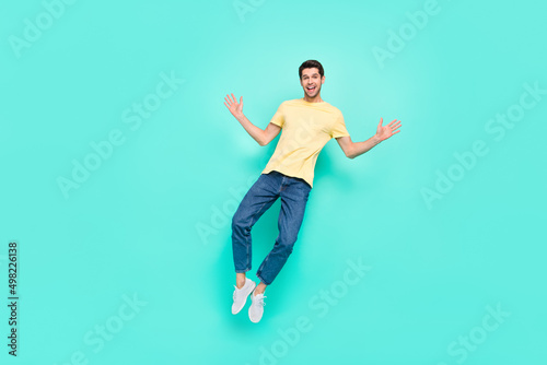 Fototapeta Naklejka Na Ścianę i Meble -  Full size photo of overjoyed energetic person jump fly have good mood isolated on turquoise color background