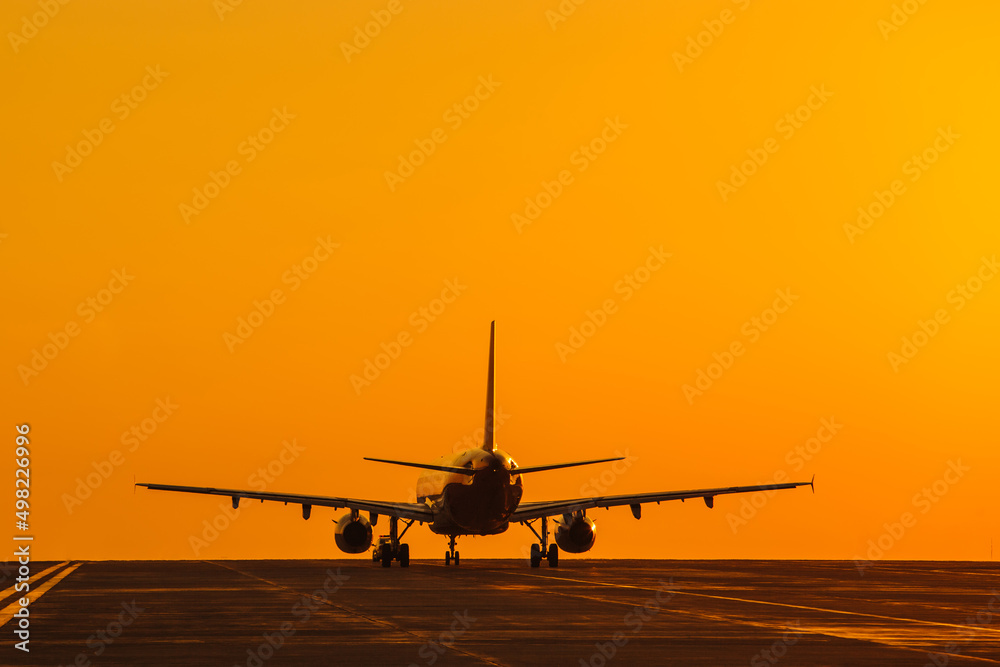 Silhouette of air plane landing at sunset with beautiful red sky in background. Evacuation Silhouette of air plane landing at sunset with beautiful red sky in background. Evacuation