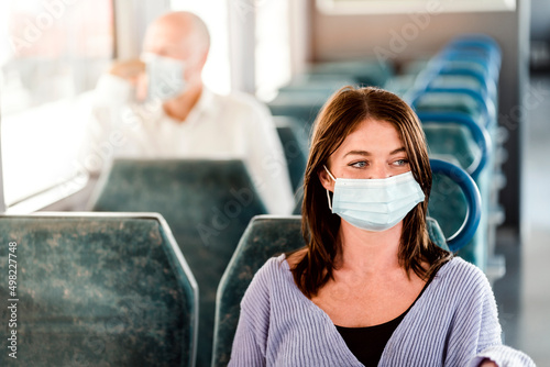 Serious passengers in protective masks during their train trip