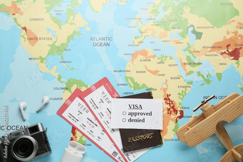 Flat lay composition with passport and tickets on world map. Space for text