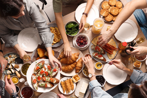 Group of people having brunch together at table, top view photo