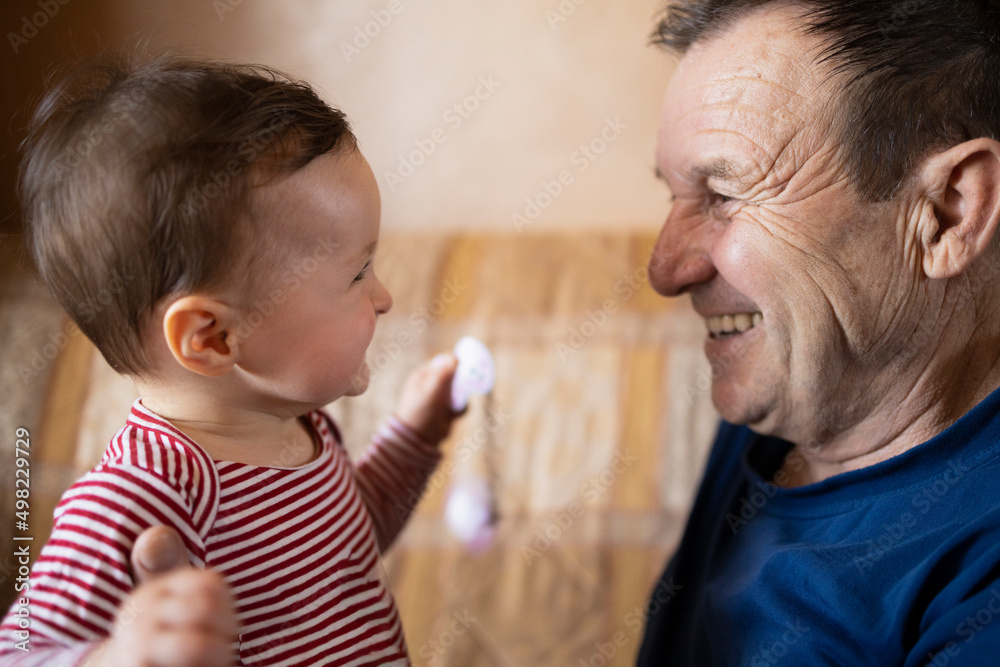 Happy baby and her grandpa smiling to each other Happy baby and her grandpa smiling to each other