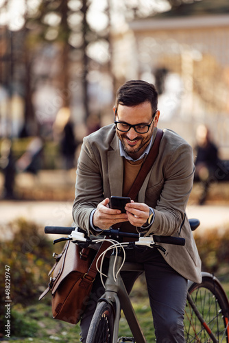 Lovely, bearded caucasian man, stopping his bike ride, typing a text.