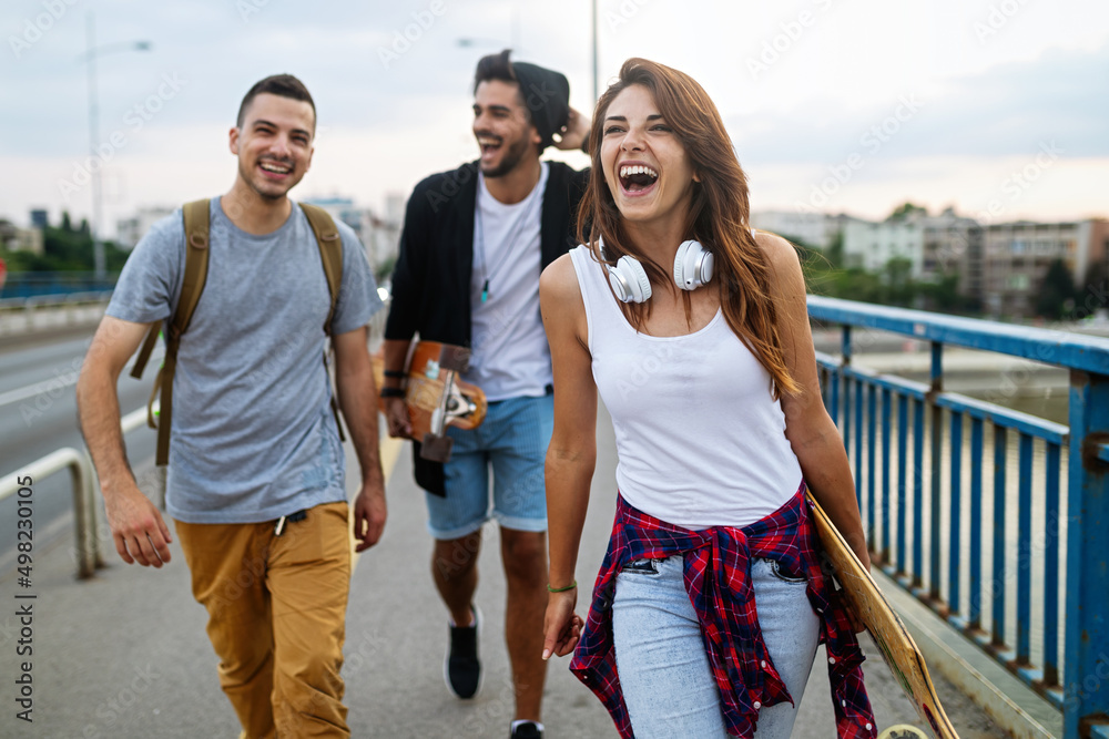 Group of happy teen people hang out together and enjoying skateboard outdoors. - obrazy, fototapety, plakaty 