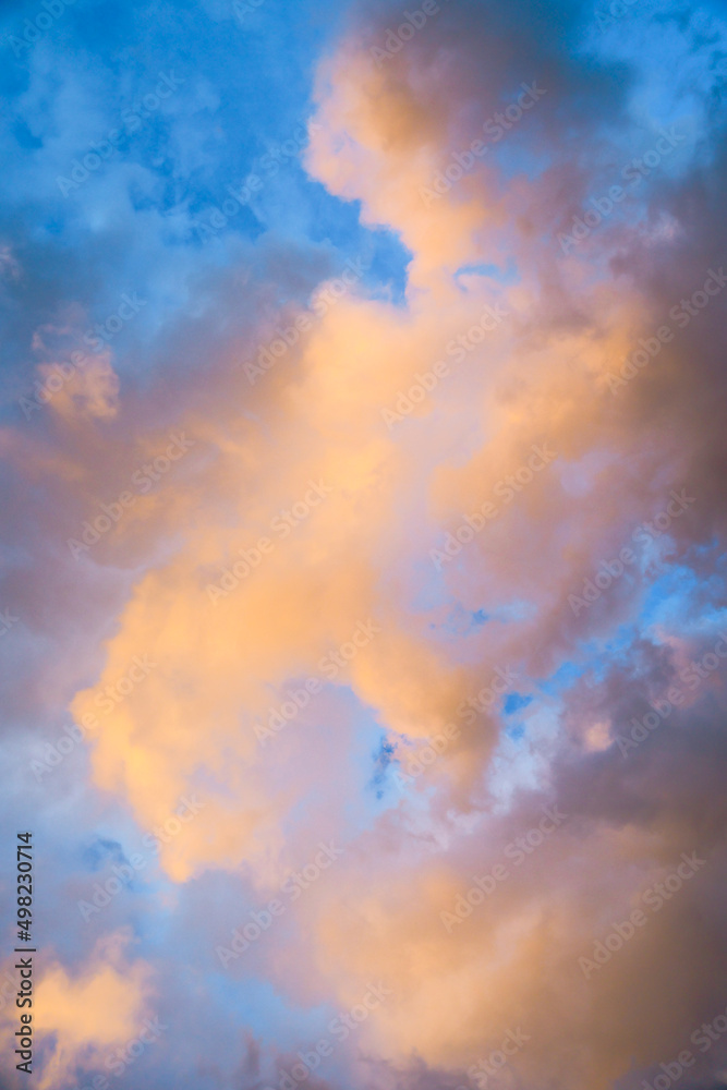 Pastel yellow, orange, pink, lilac, purple colorful clouds during sunrise twilight for background.
