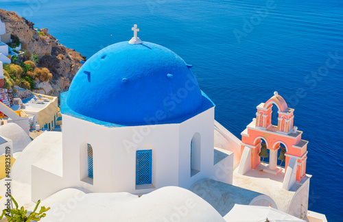 Fototapeta Naklejka Na Ścianę i Meble -  Santorini, Greece. Panoramic view of traditional houses in Santorini. Small narrow streets and rooftops of houses, churches and hotels. Oia village, Santorini Island, Greece.