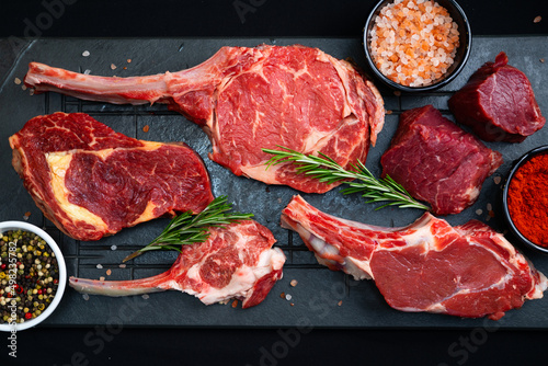 raw meat on a black board with salt and rosemary
