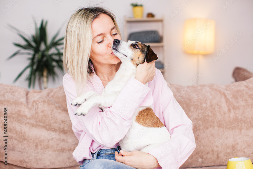 middle aged woman is resting with dog on the couch at home middle aged woman is resting with dog on the couch at home