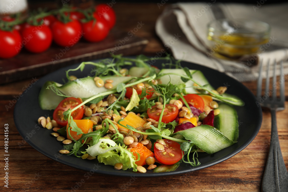 Delicious salad with lentils and vegetables on wooden table, closeup