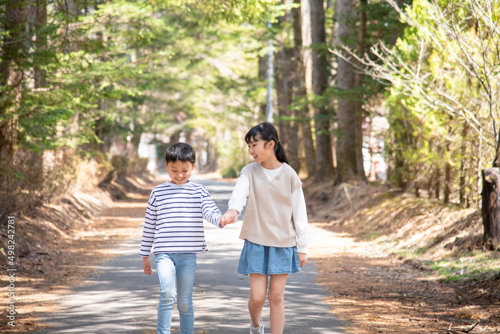 軽井沢の自然を手を繋いで歩くアジア人の子供