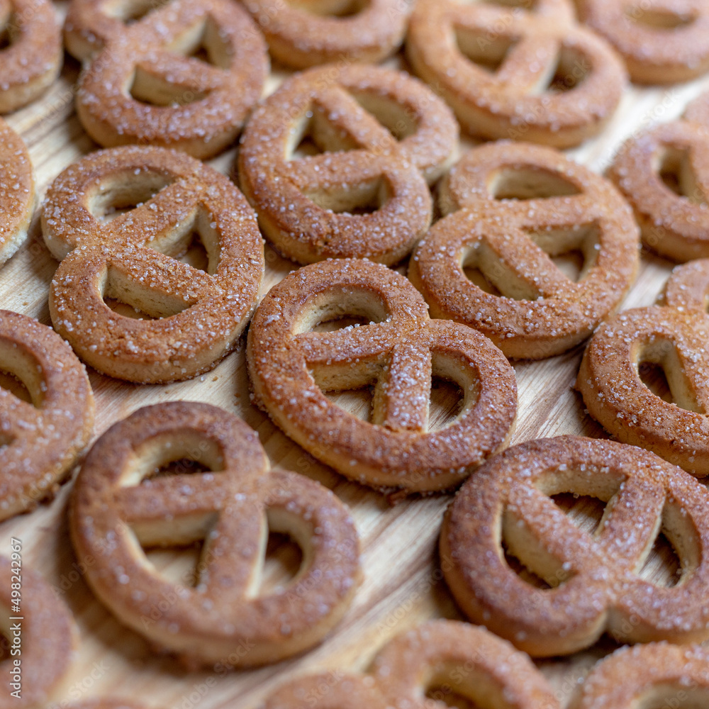 Pretzels sprinkled with sugar lie on a wooden surface Pretzels sprinkled with sugar lie on a wooden surface