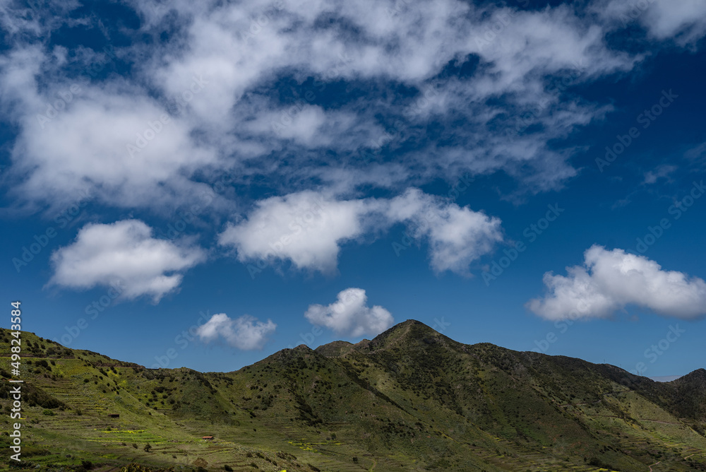 Summer landscape of green mountains and blue sky with clouds