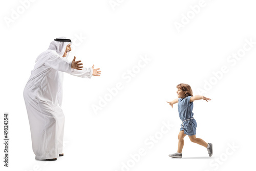 Full length profile shot of a little girl running towards an arab man in ethnic clothes