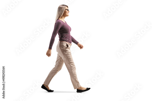 Full length profile shot of a casual blond young woman with glasses walking photo