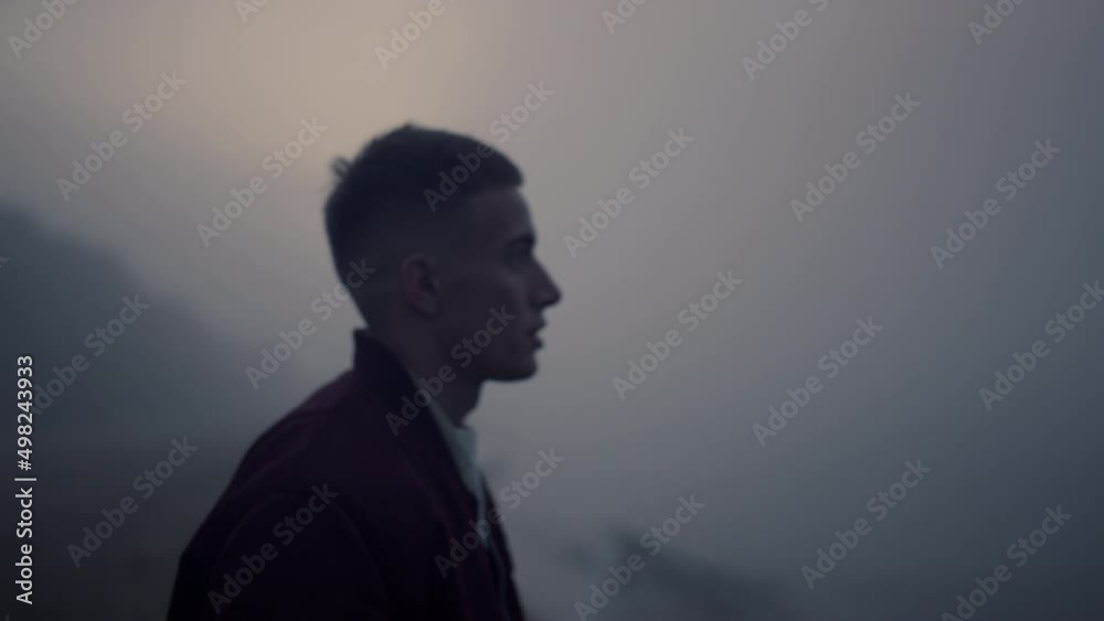 Serious man walking on sea shore in morning fog. Angry guy screaming on beach Serious man walking on sea shore in morning fog. Angry guy screaming on beach