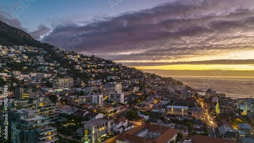 Breath taking view of apartment buildings and guesthouses on slope at sea coast in tourist destination. Hyperlapse shot against sunset sky view clouds. South Africa