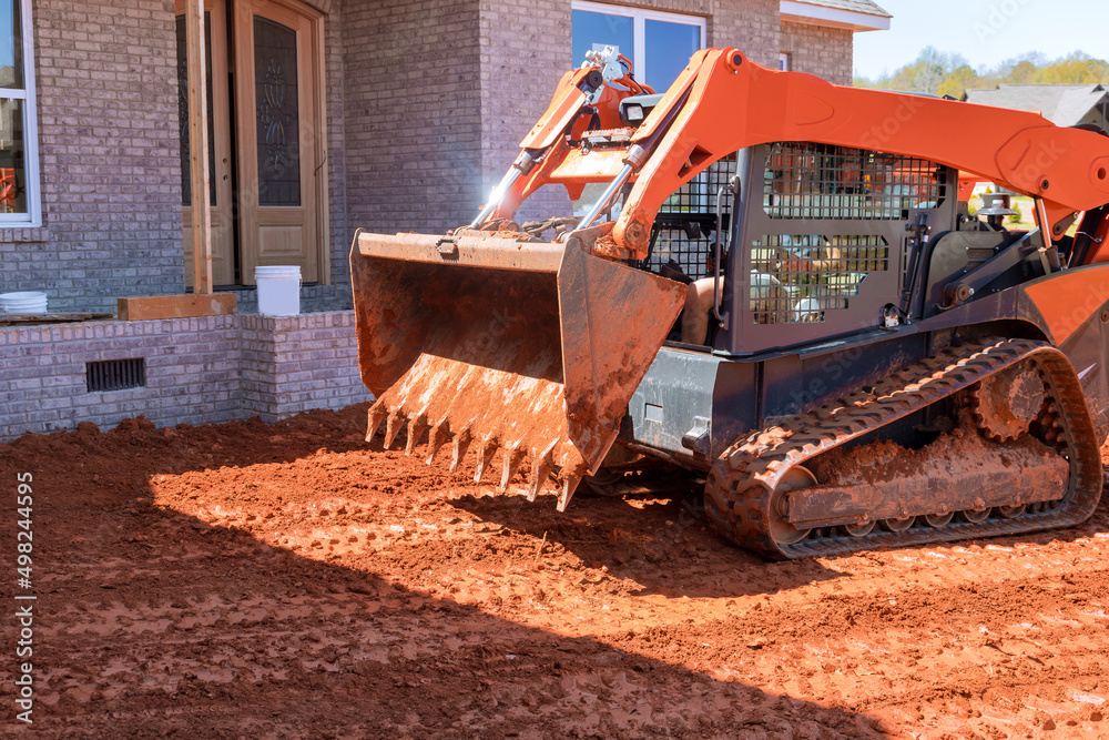 Moving soil with landscaping works equipment a excavationon the construction site in earth