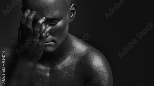 Photos A male figure with one hand covering his face and an expression of anguish on a dark background
