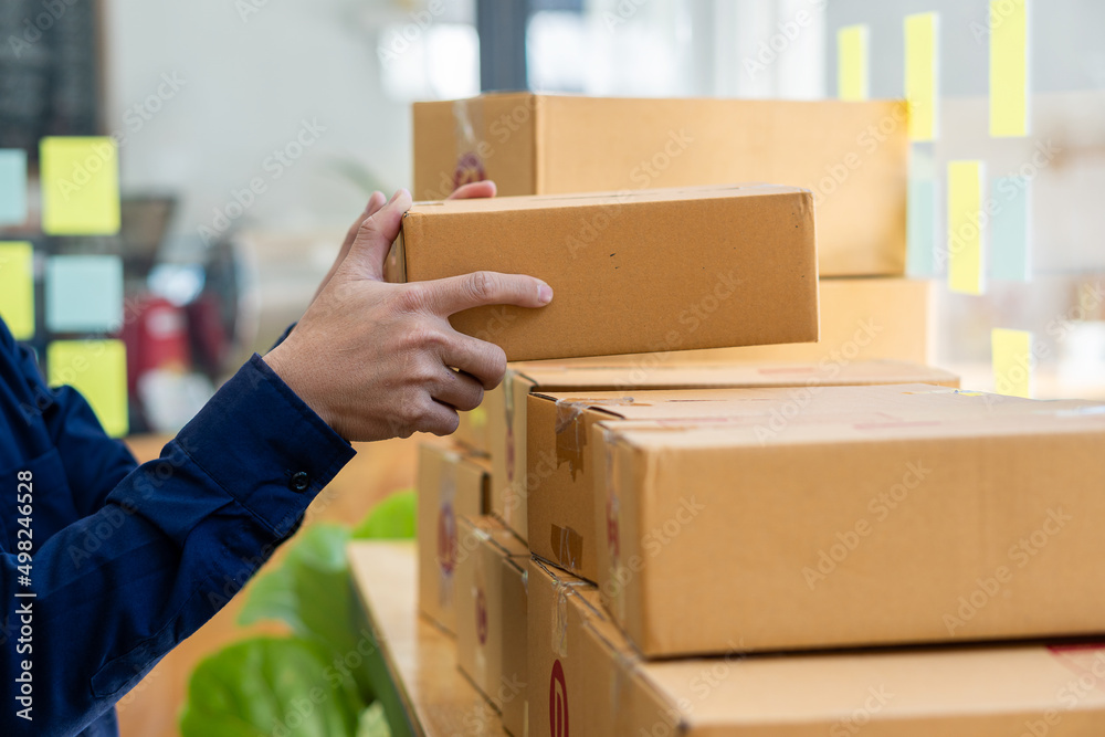 Small entrepreneurs start their SME business at home by arranging their products in yellow parcel boxes. The idea is to start selling online with laptops for taking orders and shipping. Small entrepreneurs start their SME business at home by arranging their products in yellow parcel boxes. The idea is to start selling online with laptops for taking orders and shipping.