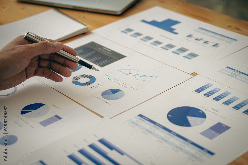 Fototapeta premium The accountant's hand holds a data graph for reporting. while still holding the pen in your finger and the calculator when done calculating can be saved for business and marketing analysis