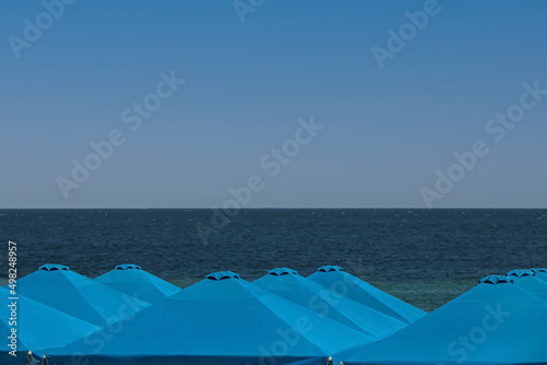 Many beach umbrellas at resort on sunny day