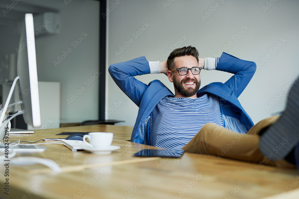 What a productive day its been. Shot of a young businessman taking a break with his feet up on the desk in an office. What a productive day its been. Shot of a young businessman taking a break with his feet up on the desk in an office.