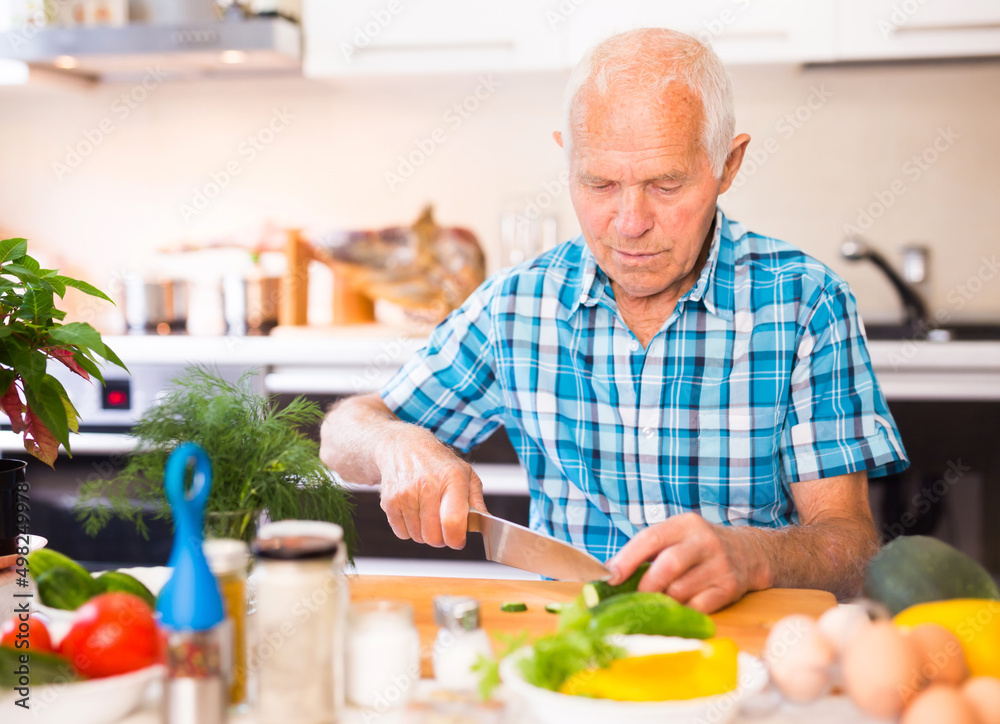 senor man preparing fresh vegetable salad at home in the kitchen senor man preparing fresh vegetable salad at home in the kitchen