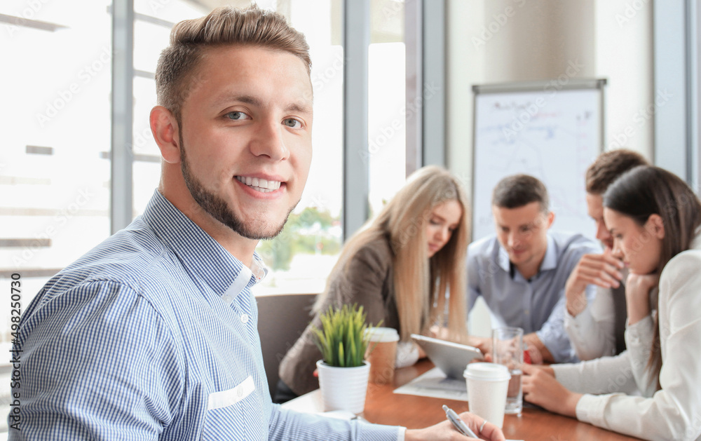 Businessman with colleagues in the background in office Businessman with colleagues in the background in office
