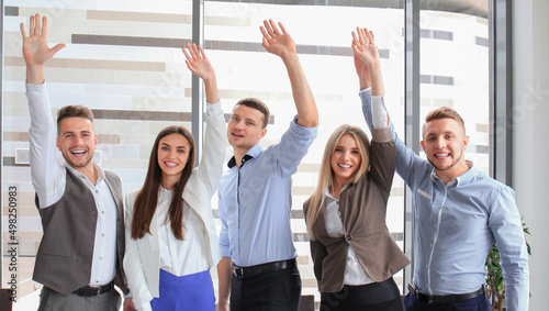Portrait of successful business group waving hands in office © ty