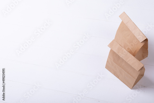 High angle view of brown paper lunch bags over white background with copy space