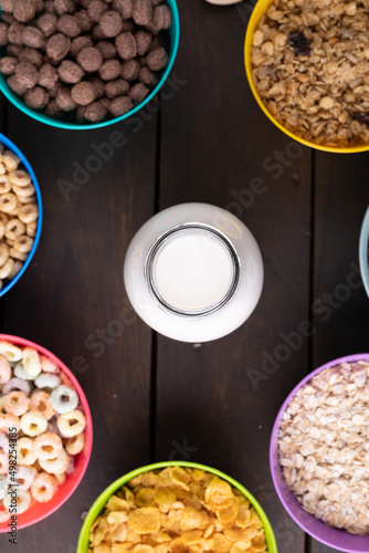 Directly above shot of milk bottle by various breakfast cereals on table