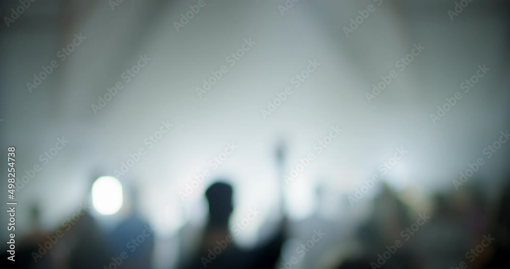 Blurred Unrecognizable People Audience on Music Live Concert or Show Event with Lights. Christians Worship and Praise on Festival or Conference. 4K wide handheld shot in slow motion with rack focus