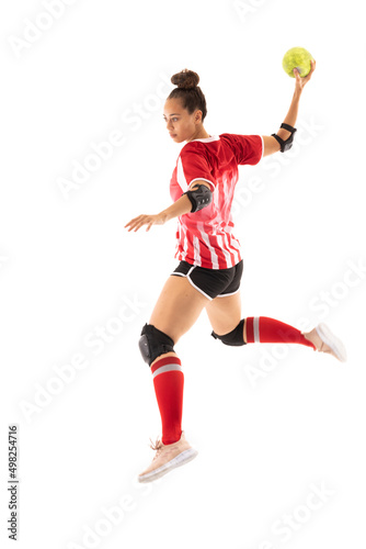 Biracial young female sports player in mid-air with handball playing against white background