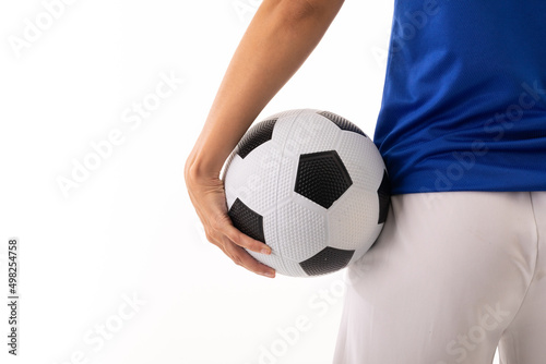 Close-up midsection of biracial young female soccer player with soccer ball against white background