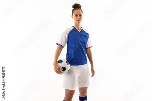 Fotografija Portrait of biracial young female soccer player with soccer ball standing agains