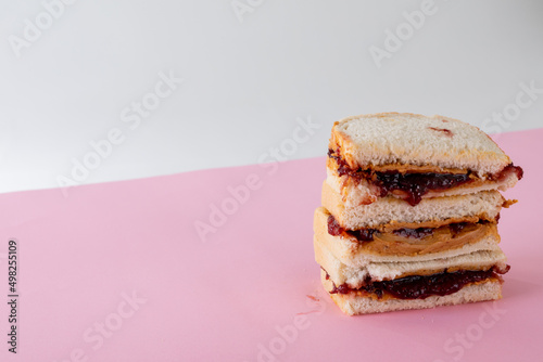 Close-up of stacked peanut butter and jelly sandwiches on table against gray background