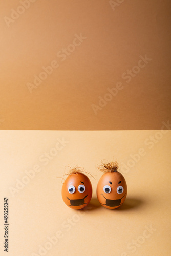 Easter eggs with mask painting and doodle eyes against orange background