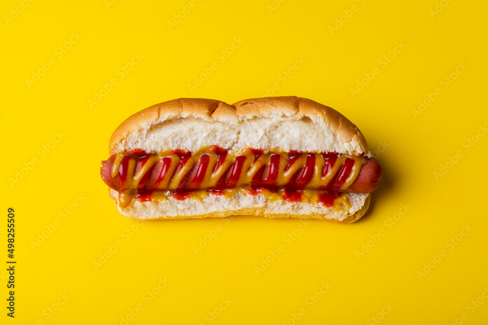 Close-up of hot dog on yellow background Close-up of hot dog on yellow background