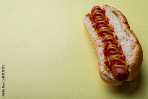 Close-up of hot dog over yellow background with copy space