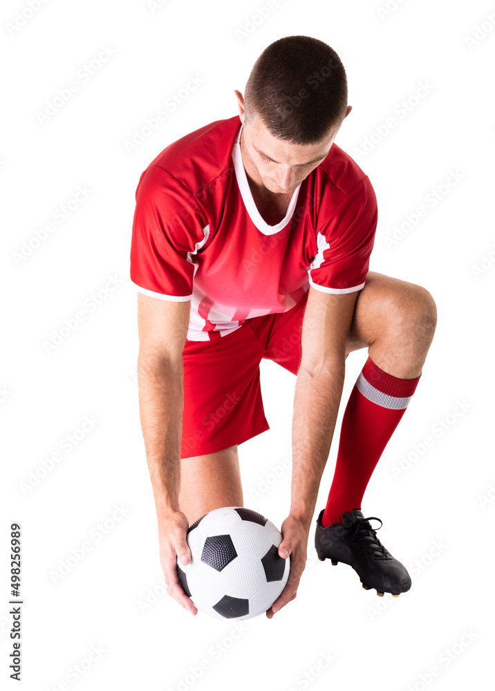 Full length of caucasian young male soccer player kneeling while holding ball over white background