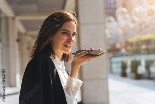 Young beautiful woman using smartphone voice messager , emotional hispanic woman talk with friend on loud speaker or using voice recognition on cellphone
