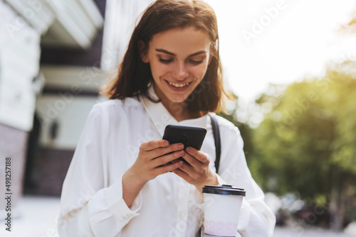 Happy woman texting with friends while walking outdoor at the spring