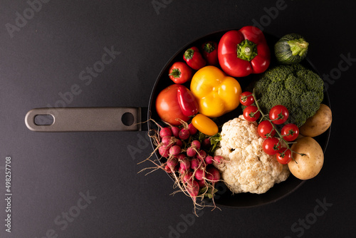 Directly above shot of various vegetables in frying pan on black background