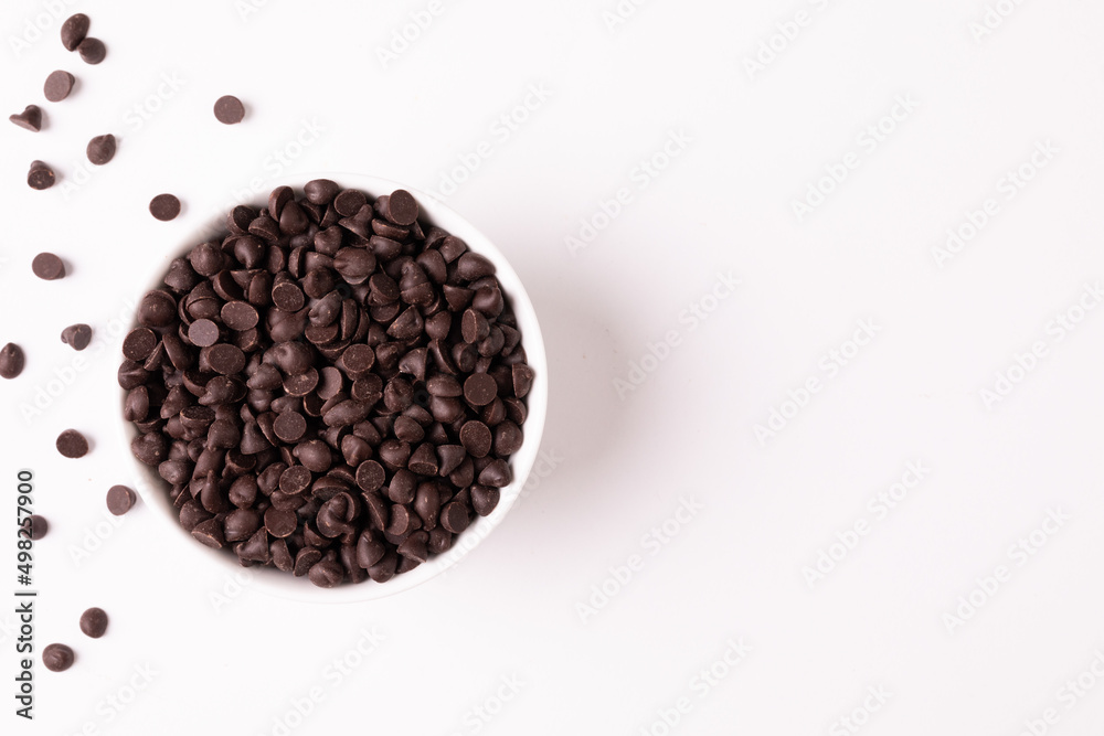 Overhead view of bowl full of chocolate chips by copy space on white background Overhead view of bowl full of chocolate chips by copy space on white background