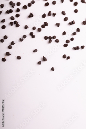 Directly above view of fresh chocolate chips scattered over copy space on white background