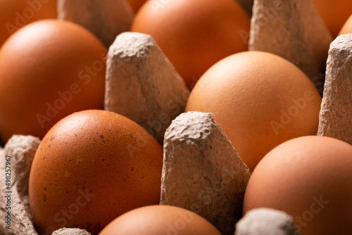 Full frame close-up shot of fresh brown eggs on carton